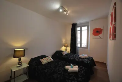 a small room with two beds and a window at Le Vieux Port Apartments in Cannes