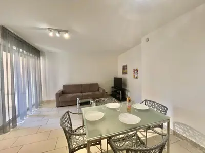 a dining room with a table and chairs and a couch at Le Vieux Port Apartments in Cannes