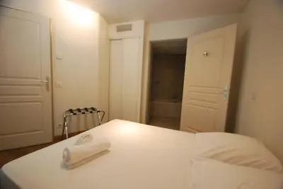 a bedroom with a white bed with a towel on it at Le Vieux Port Apartments in Cannes