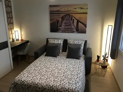 a bedroom with a bed with a painting on the wall at Lovely Studio Cannes in Cannes