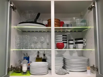 a cabinet filled with plates and glasses and dishes at Lovely Studio Cannes in Cannes