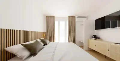a bedroom with a large white bed and a window at Hotel le Romanesque in Cannes