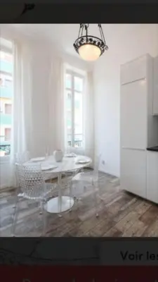 a white dining room with a table and chairs at Ice coeur de Cannes in Cannes