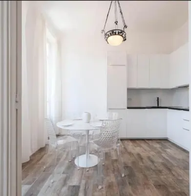 a white kitchen with a table and chairs in a room at Ice coeur de Cannes in Cannes