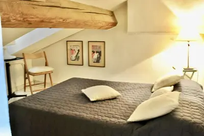 a bedroom with a bed with pillows and a chair at Le Napoléon 3P SAM1437 in Cannes