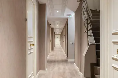 a corridor with a long hallway with white walls and stairs at Palais Rouaze Cannes in Cannes