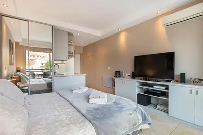 a bedroom with a large bed and a television at Palais Rouaze Cannes in Cannes