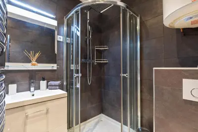 a bathroom with a glass shower and a sink at Palais Rouaze Cannes in Cannes