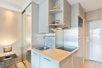 a kitchen with white cabinets and a sink at Palais Rouaze Cannes in Cannes