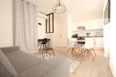 a living room with a couch and a table and chairs at Cosy-Cocoon in Cannes