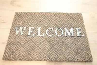 a welcome mat on a wooden floor with the word welcome at Cosy-Cocoon in Cannes