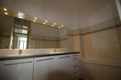 a bathroom with two sinks and a mirror and a tub at AGENCIA apartement 3 PIECES RUE D'ANTIBES in Cannes