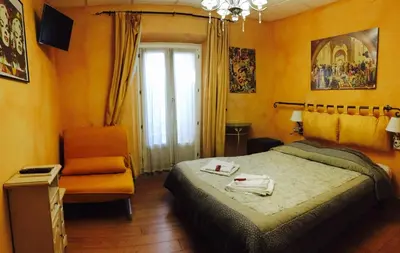 a bedroom with a bed and a chair and a window at Boutique Hotel Couleurs Suds in Cannes