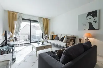 a living room with a couch and a table at Appartement de charme à Cannes + terrasse in Cannes