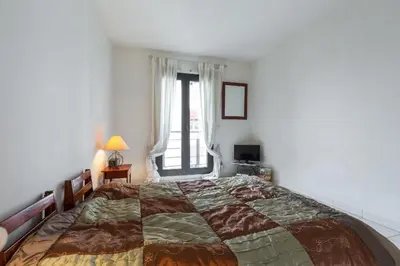 a bedroom with a large bed and a window at Appartement de charme à Cannes + terrasse in Cannes