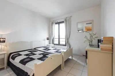 a bedroom with a bed and a desk and a window at Appartement de charme à Cannes + terrasse in Cannes