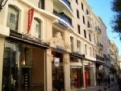 a tall building with windows on a city street at Appartement de charme à Cannes + terrasse in Cannes
