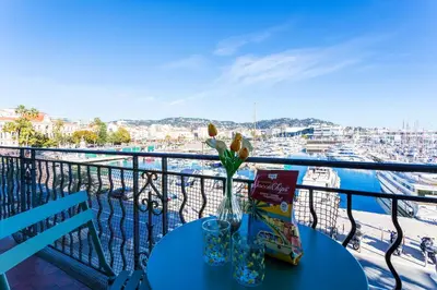 a table on a balcony with a view of a harbor at Le Saint-Pierre PET231 2P in Cannes