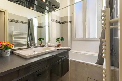 a bathroom with a sink and a mirror and a tub at Le Saint-Pierre PET231 2P in Cannes