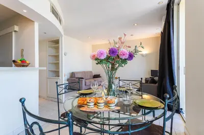 a dining room table with a vase of flowers on it at Le Saint-Pierre PET231 2P in Cannes