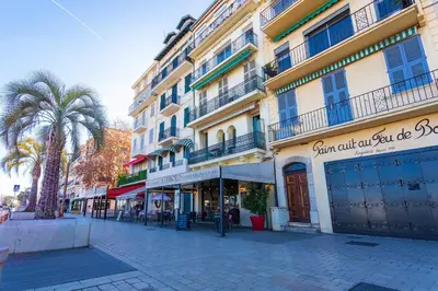 a city street with a building and palm trees at Le Saint-Pierre PET231 2P in Cannes