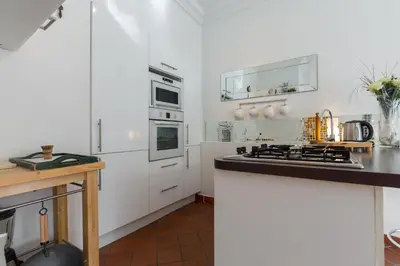 a white bedroom with a white dresser and a mirror at A lovely split level townhouse in the heart of Cannes next to the Marche Forville and the Palais 1749 in Cannes
