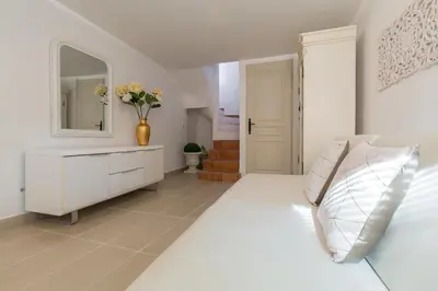 a living room with a couch and a tv on the wall at A lovely split level townhouse in the heart of Cannes next to the Marche Forville and the Palais 1749 in Cannes