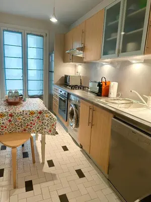 a kitchen with a table and a sink and a stove at AGENCIA appartement 2 chambres LE CORFOU in Cannes