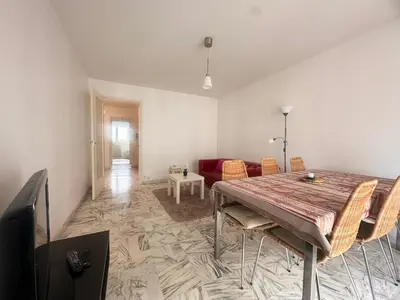 a living room with a table and a couch at AGENCIA appartement 2 chambres LE CORFOU in Cannes