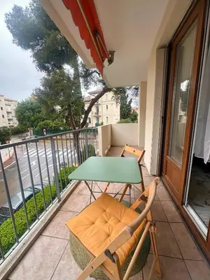 a balcony with a green table and chairs on it at AGENCIA appartement 2 chambres LE CORFOU in Cannes