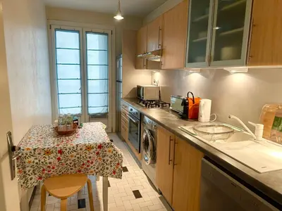 a small kitchen with a table and a sink at AGENCIA appartement 2 chambres LE CORFOU in Cannes
