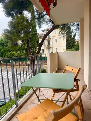 a balcony with a green table and chairs on a balcony at AGENCIA appartement 2 chambres LE CORFOU in Cannes