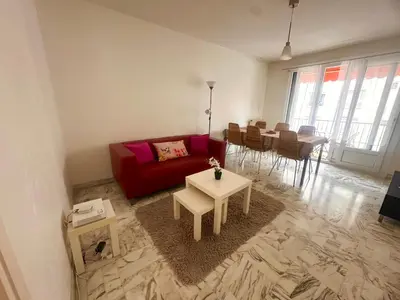 a living room with a red couch and a table at AGENCIA appartement 2 chambres LE CORFOU in Cannes