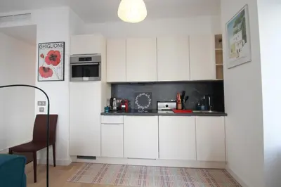 a kitchen with white cabinets and a counter top at Palais Foch in Cannes