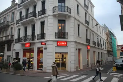 a white building with people walking in front of it at Palais Foch in Cannes
