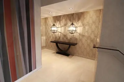 a hallway with a table and two lights on the wall at Palais Foch in Cannes