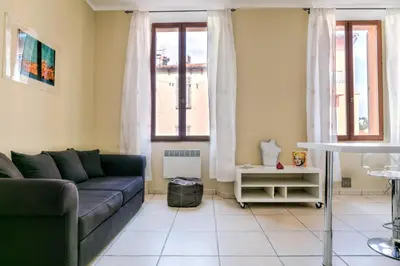 a living room with a couch and two windows at IMMOGROOM - Historic Area Le Suquet - 6min from the beaches in Cannes