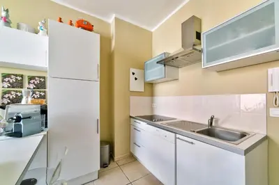 a kitchen with white cabinets and a sink at IMMOGROOM - Historic Area Le Suquet - 6min from the beaches in Cannes