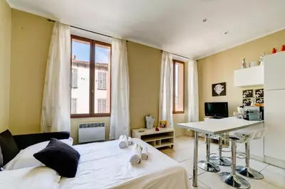 a bedroom with a bed and a desk and a table at IMMOGROOM - Historic Area Le Suquet - 6min from the beaches in Cannes
