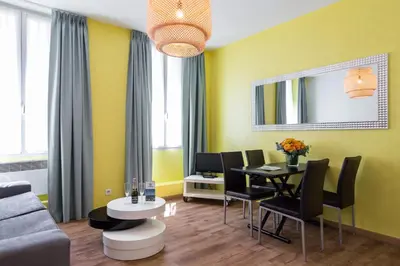a living room with yellow walls and a table and chairs at Florella Clemenceau Apartment in Cannes