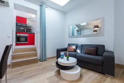 a living room with a couch and a table at Florella Clemenceau Apartment in Cannes