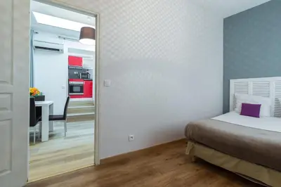 a bedroom with a bed and a table and a mirror at Florella Clemenceau Apartment in Cannes