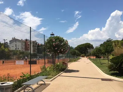 a park with a bench next to a fence at Appartements Cannes in Cannes