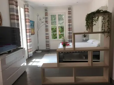 a living room with a tv and a table at Appartements Cannes in Cannes