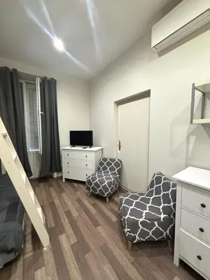 a bedroom with a bed and a desk and a chair at Résidence Gambetta in Cannes