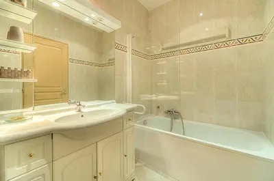 a white bathroom with a sink and a tub and a tubermott at Residence Chryseis in Cannes