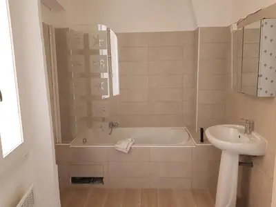 a bathroom with a bath tub and a sink at Residence Chryseis in Cannes