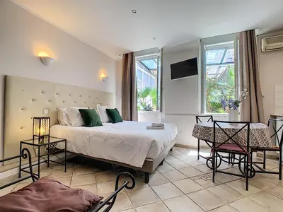 a bedroom with a bed and a table and chairs at Residence Chryseis in Cannes