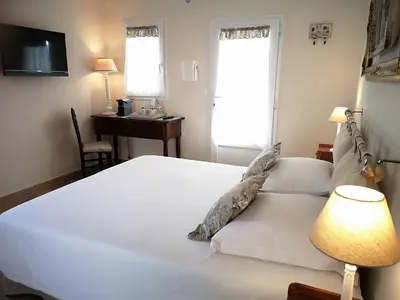 a bedroom with a large white bed and a desk at B&B Villa Blanche in Cannes
