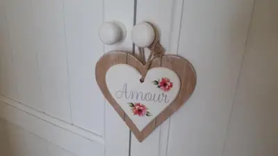 a wooden heart hanging on a wall with flowers at B&B Villa Blanche in Cannes